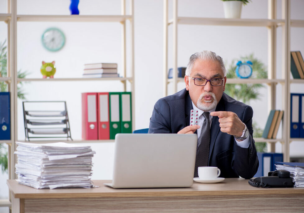 Old male employee feeling bad in the office